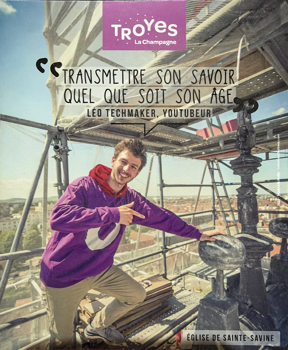 Fier de Troyes campaign visual: Léo on the scaffolding of the Sainte-Savine church, with his quote “Pass on your knowledge, whatever your age”